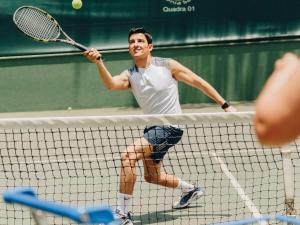 un hombre golpeando una pelota de tenis con raqueta en Grand Mercure Sao Paulo Ibirapuera, en São Paulo