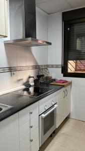 uma cozinha com um lavatório e um fogão em Apartamentos Arcos Duplex Águilas em Águilas