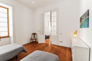 een slaapkamer met witte muren en een hardhouten vloer bij Guia Getaway Private Rooms in Santa Maria de Guia de Gran Canaria