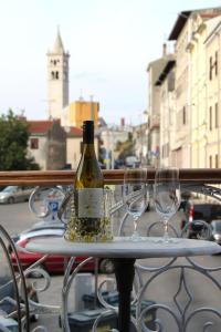 a bottle of wine sitting on a table with two glasses at Ana Apartment in Pula