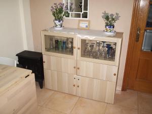 un armario de madera con botellas y jarrones encima en Gran Alacant Apartment, en Puerto Marino