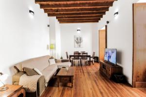 een woonkamer met een bank, een tv en een tafel bij Guia Getaway Private Rooms in Santa Maria de Guia de Gran Canaria