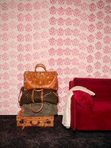 a pile of luggage sitting next to a red couch at Huber's Boutique Hotel in Mayrhofen