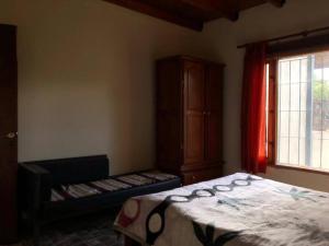 - une chambre avec un lit, une armoire et une fenêtre dans l'établissement Tu rincón en la montaña, à El Mollar