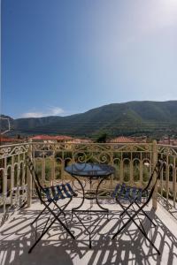 una mesa y sillas en un balcón con vistas en Kraka Apartments, en Leonidio