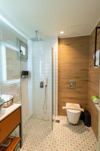 a bathroom with a glass shower and a toilet at Kraka Apartments in Leonidio