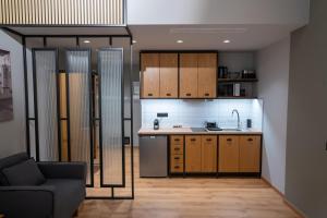 a kitchen with wooden cabinets and a couch in a room at Kraka Apartments in Leonidio