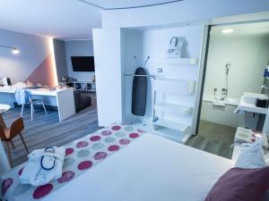 a bedroom with a bed and a room with a desk at Novotel Suites Luxembourg in Luxembourg