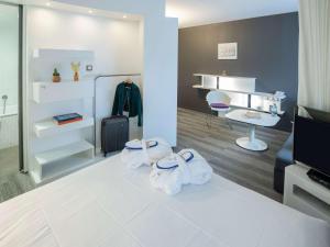 a room with a bed with towels on the floor at Novotel Suites Luxembourg in Luxembourg