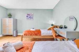 two beds in a room with a desk and a mirror at CADeS West Bromwich in West Bromwich