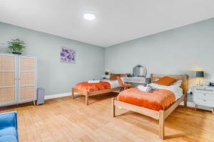 two beds in a room with wooden floors at CADeS West Bromwich in West Bromwich