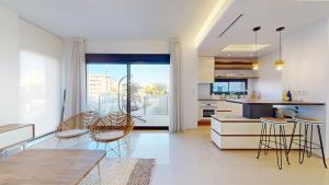 uma cozinha com cadeiras, uma mesa e um balcão em Elegant apartment with pool AC and balcony em Arenales del Sol