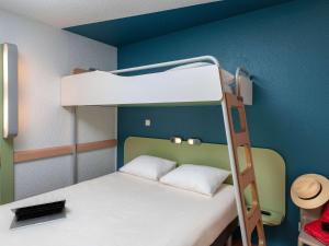 ein kleines Zimmer mit einem Etagenbett mit einer Leiter in der Unterkunft ibis Budget Mâcon Sud in Mâcon