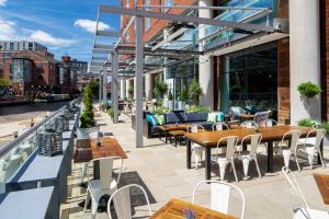 een patio met tafels en stoelen in een gebouw bij DoubleTree by Hilton Leeds in Leeds