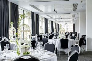 una habitación llena de mesas y sillas con manteles blancos en DoubleTree by Hilton Leeds, en Leeds