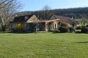 a house with a grass yard in front of it at Le Domaine des Crouquets in Jayac