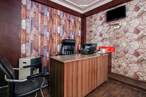 um escritório com uma parede de pedra e uma secretária em City Star Hotel & Restaurant em Jawāharnagar