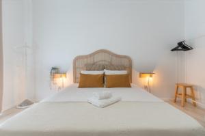 um quarto com uma grande cama branca e 2 almofadas em Galagana Charm House na Golegã