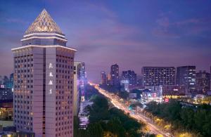 ein hohes Gebäude in einer Stadt in der Nacht in der Unterkunft BEI Zhaolong Hotel, JdV by Hyatt in Peking
