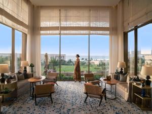 a woman standing in a room with a large window at Fairmont Taghazout Bay in Taghazout