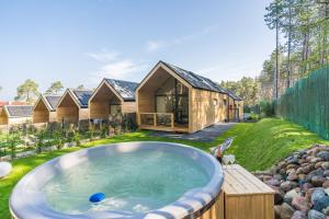 ein Haus mit einem Whirlpool im Hof in der Unterkunft Bursztynowo in Kąty Rybackie