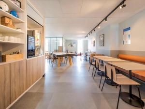 a dining room with wooden tables and chairs at ibis budget Forbach Centre in Forbach