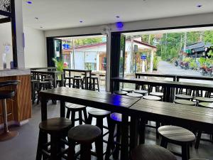 un restaurant avec des tables et des chaises en bois et une fenêtre dans l'établissement Eclipse Hostel and Bar, à Haad Rin