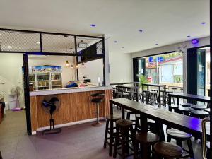 un restaurant avec un bar doté de tables et de tabourets en bois dans l'établissement Eclipse Hostel and Bar, à Haad Rin