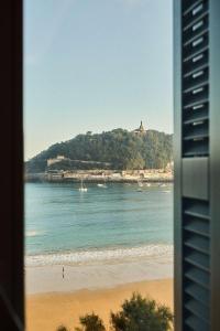 a view of a beach with boats in the water at Nobu Hotel San Sebastián in Donostia-San Sebastián