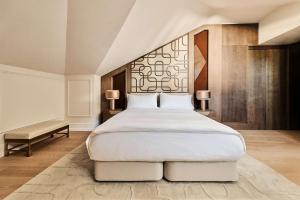 a bedroom with a large white bed and two lamps at Nobu Hotel San Sebastián in Donostia-San Sebastián