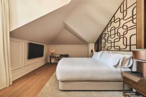 a bedroom with a large bed and a tv at Nobu Hotel San Sebastián in Donostia-San Sebastián