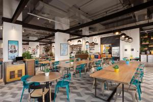 a restaurant with wooden tables and blue chairs at Rove City Walk in Dubai