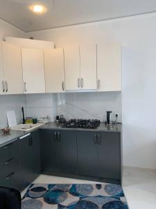 a kitchen with white cabinets and a stove top oven at Agarak House 