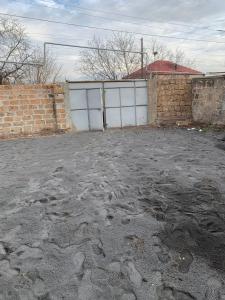 a driveway with a white gate and a brick wall at Agarak House 