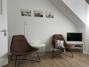 two chairs in a living room with a television at Stadtstudio Saarlouis in Saarlouis