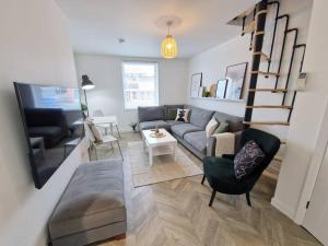 een woonkamer met een bank en een wenteltrap bij Koselig Properties in Lerwick