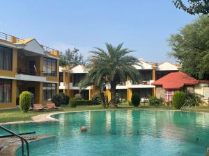 uma piscina em frente a alguns apartamentos em Sariska Tiger Heaven em Akbarpur