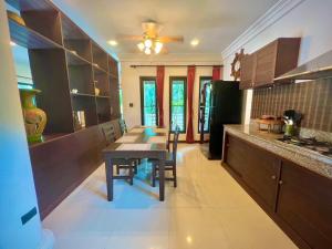 a kitchen with a table and a dining room at Grand Villa Khaolak in Khao Lak
