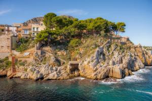 an island in the ocean with houses on a cliff at Nelly Casa Vacanze in Porticello