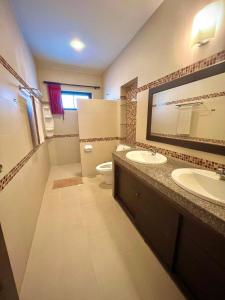 a bathroom with a sink and a toilet and a mirror at Grand Villa Khaolak in Khao Lak
