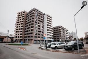 a parking lot with cars parked in front of tall buildings at AH Albelli II in Košice