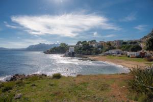 a view of a beach with houses and the ocean at Nelly Casa Vacanze in Porticello
