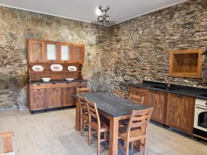 a kitchen with a table and a stone wall at Quinta da Coitada - Alojamento Local in Soutelo do Douro