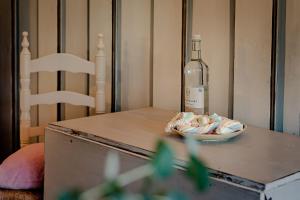una bottiglia di vino seduta su un tavolo con una ciotola di pillole di Im Lütten a Braderup