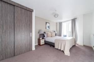 a bedroom with a bed and a large window at The Lewisham Collection in London