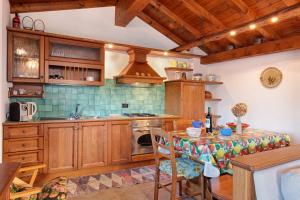 una cucina con armadi in legno, tavolo e piano cottura di Baita Margherita a Casargo