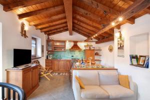 a living room with a couch and a kitchen at Baita Margherita in Casargo