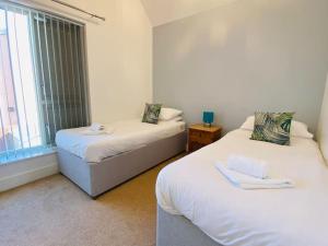 two beds in a room with a window at Olympic Village Vela - Portland in Portland