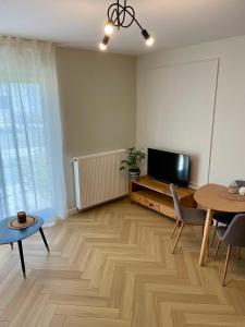 a living room with a television and a table and chairs at Warsaw City Break II in Pruszków