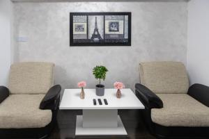 uma sala de espera com duas cadeiras e uma mesa branca em Exclusive Apartment em Giurgiu